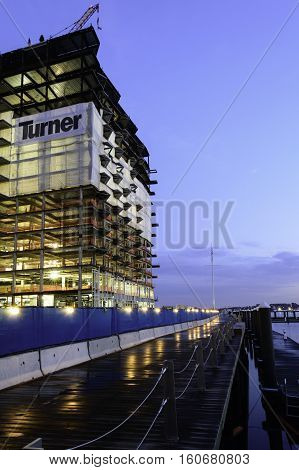 South Boston Massachusetts USA - December 8 2016: Slippery Harborwalk glistens below rising steel frame of 50 Liberty project in South Boston