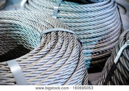 Coils of steel cable. Several steel wire rope rings stacked on the floor.