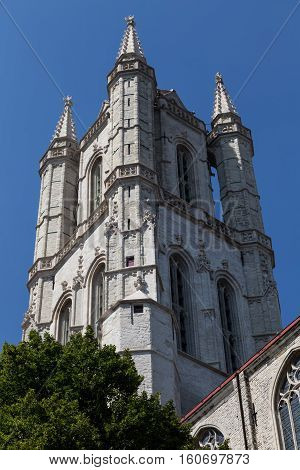Saint Bavo Cathedral Ghent Belgium - tip close up on background of bright blue sky