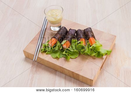 Salad roll vegetables with seaweed wrap on wooden table