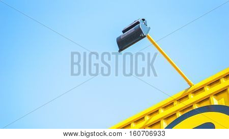 Spotligth lamp and building concept - Close up back side of outdoor spotlight lamp with yellow container wall and copy space