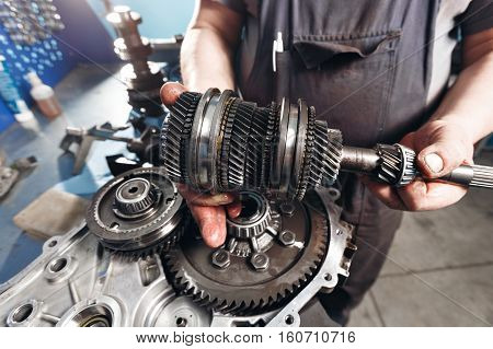 Cross-section of a car gearbox. mechanics work in the garage. hand car mechanic in working clothes.
