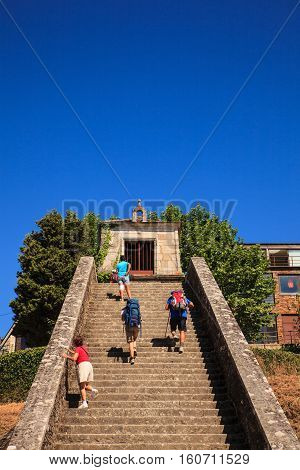 PORTOMARIN SPAIN - AUGUST 12: Pilgrims ascending the Roman staircase on August 12 2016