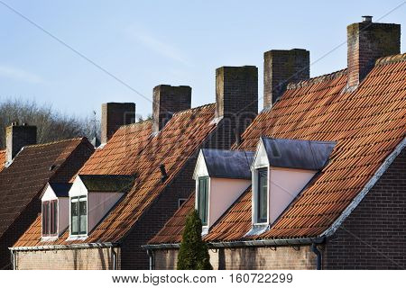 Old picturesque red tiled roofs with dormers and chimneys in the Netherlands