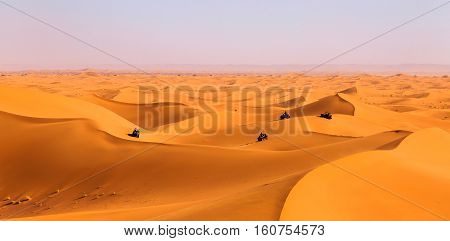 Tourists Driving Quads And All-terrain Vehicles In Sahara Dunes