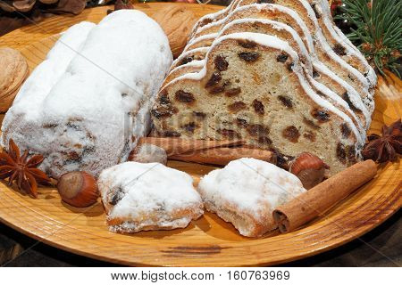 Christmas stollen with Christmas decoration on a wooden plate