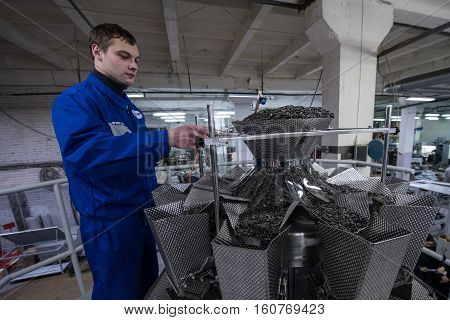 Worker Working On The Machine For Packing Loose Food