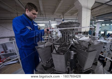 Worker Working On The Machine For Packing Loose Food