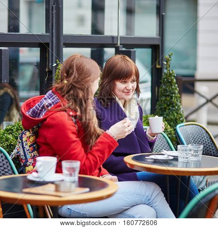Two Cheerful Young Girls In A Parisian Street Cafe