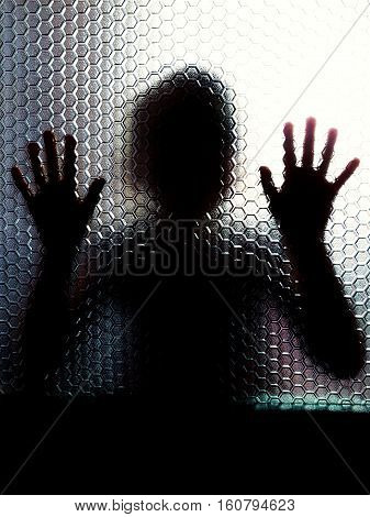 Scared child behind glass door showing hands