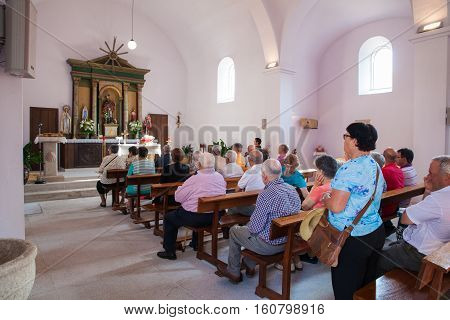 MELIDE SPAIN - AUGUST 14: People during mass in San Pedro catholic Church on August 14 2016