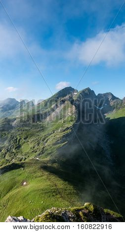 Clouds rushing past a mountain peak against the blue sky