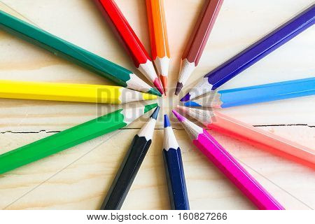 bunch of colored pencils isolated on white background and Placed on a wooden floor