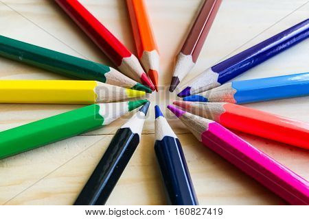 Colour pencils isolated on wood background close up