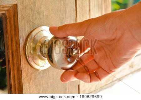 Person's hand will going to twisting and turning the dirty door knob.