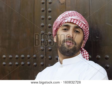 Young smiling handsome arabian man wearing traditional clothes