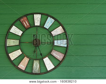 Old vintage clock on green wooden wall