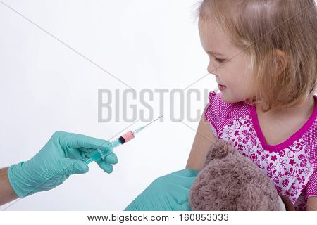 Doctor holds an injection vaccination little girl. she scerd. child is afraid and scared