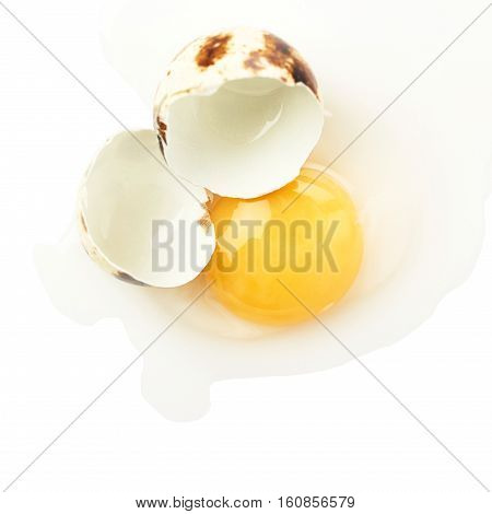 Single cracked raw quail egg with yolk isolated over white background