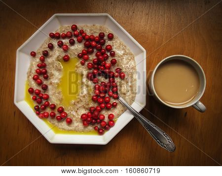 Oatmeal with butter and lingon berries and coffee mug