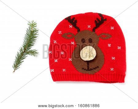 Red knitted wool hat with funny raindeer isolated on white