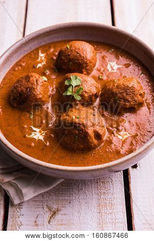 malai kofta curry - classic North Indian dish. vegetarian alternative to meatballs served with tandoori roti or indian bread and green salad, selective focus