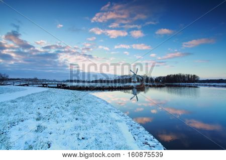 Dutch windmill by canal in winter Netherlands