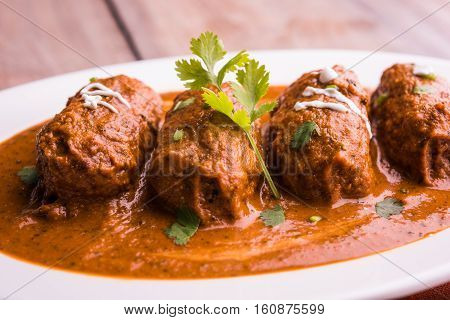 malai kofta curry - classic North Indian dish. vegetarian alternative to meatballs served with tandoori roti or indian bread and green salad, selective focus