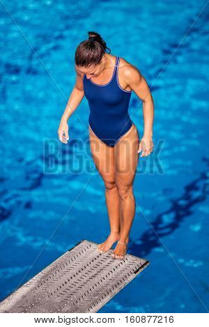 Female Diver Standing On The Jumping Board.