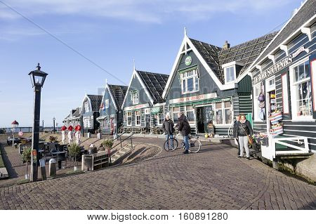 Marken, Netherlands, 22 november 2016: locals and tourists at harbor of old dutch village Marken on sunny day in november