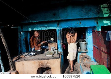 CHITRAKUT, INDIA - DEC 29, 2012: Kid at home and early morning in an Indian family father preparing breakfast on December 29, 2012. In Chitrakut by the legend 11 years have lived Lord Rama.