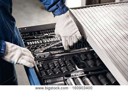 Auto mechanic with working tools For repair and diagnostics of cars in the garage Car.