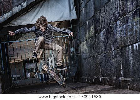 Skateboarder making board flip on urban background