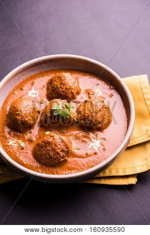 malai kofta curry - classic North Indian dish. vegetarian alternative to meatballs served with tandoori roti or indian bread and green salad, selective focus