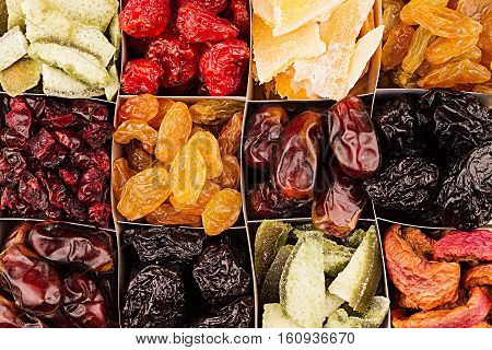 Assortment of dried fruits closeup background in square cells. Decorative pattern of dry exotic fruit. Top view.