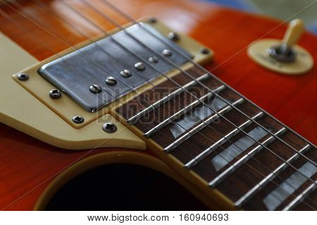 Closeup of the solid body electric guitar. Detail selective focus low key.