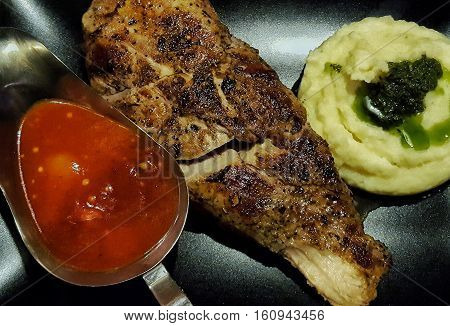 Delicious pork fillet served with mashed potato basil pesto and home made sauce