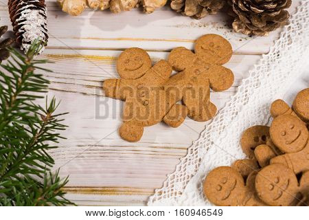 Christmas smiling gingerbread men men and women on white handmade lace with Christmas decoration