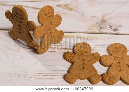 Christmas smiling gingerbread men men and women on rustic wooden background
