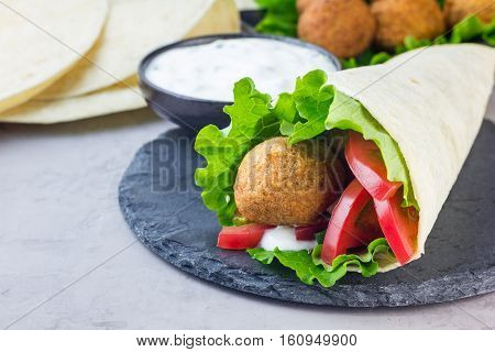 Chickpea falafel balls with vegetables and sauce roll sandwich preparation horizontal copy space