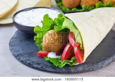 Chickpea falafel balls with vegetables and sauce roll sandwich preparation horizontal copy space