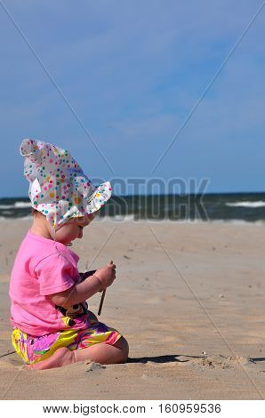 cheerfull baby playing in sand on vacations, summer trip.