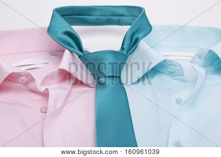 Pink shirt and turquoise shirt, turquoise tie on a white background