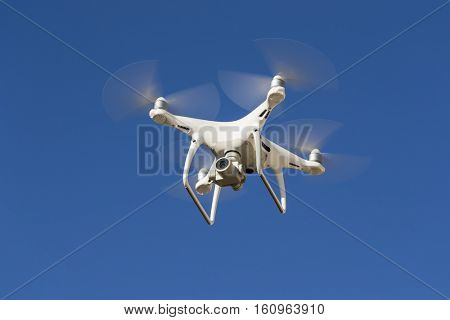A personal drone flying through the air in a urban atmosphere.