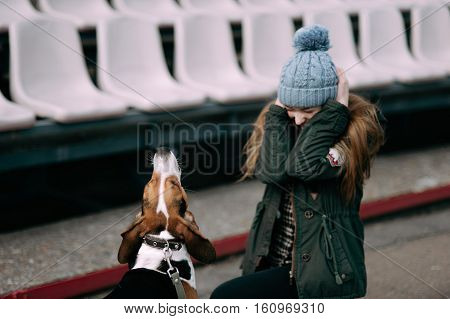Young Hipster Girl With Her Pet Estonian Hound Dog Playing, Junping And Hugging And Having Fun Outdo
