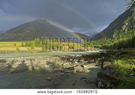 Rainbow over the river. Argut River merger with Katun. Altai Mountains Russia. August.