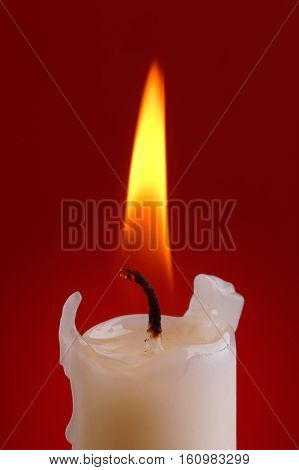 Close up of a candle light on red background.