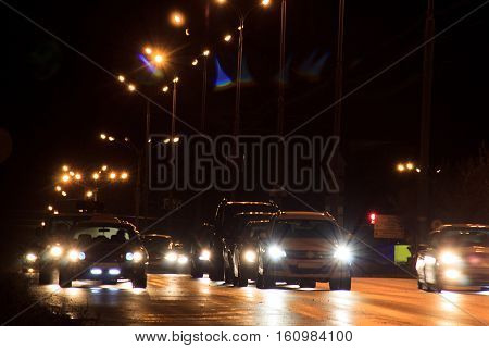 Cars drive fast on highway in night.