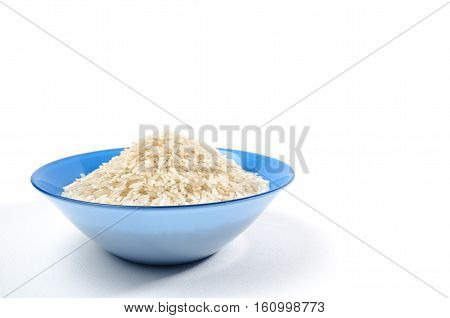 handful of long-grain rice isolated in the blue cup on left