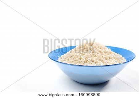 handful of long-grain rice isolated in the blue cup on right